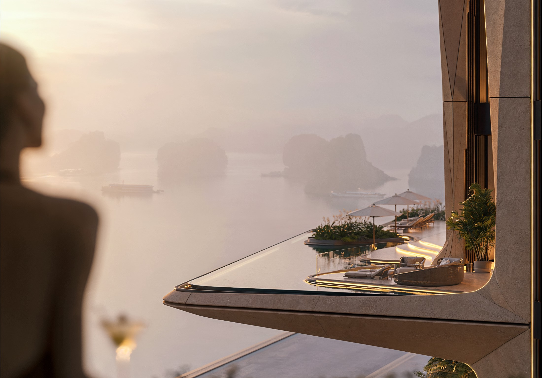 A terrace and infinity pool held out over a limestone bay at sunrise